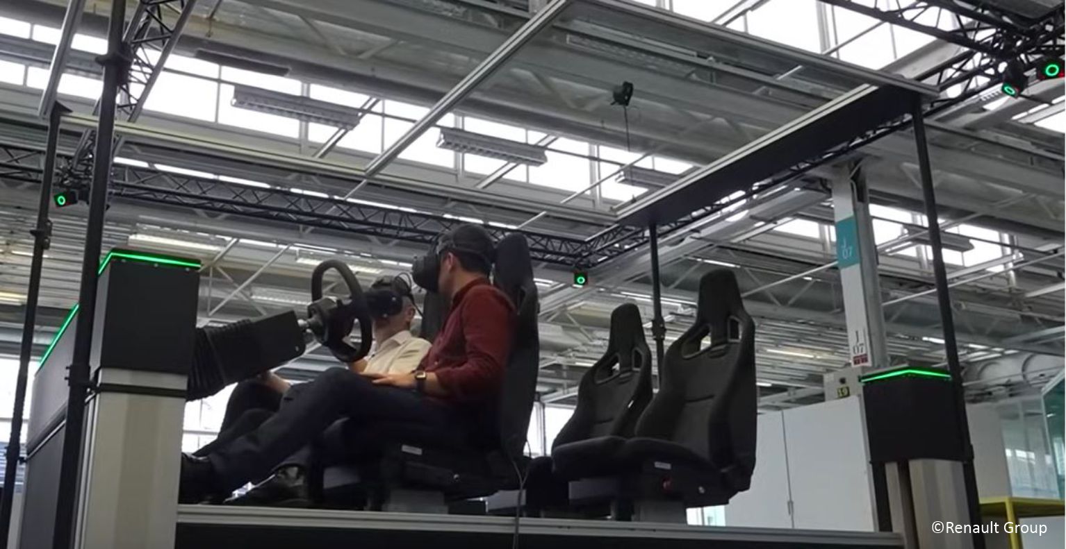 Industrie-VR-Simulator bei Renault: zwei Personen im Cockpit mit Head-Mounted Displays; rundum optische Trackingkameras an Traversen.